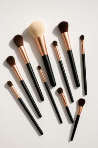 Flat lay of various makeup brushes arranged neatly on white background"